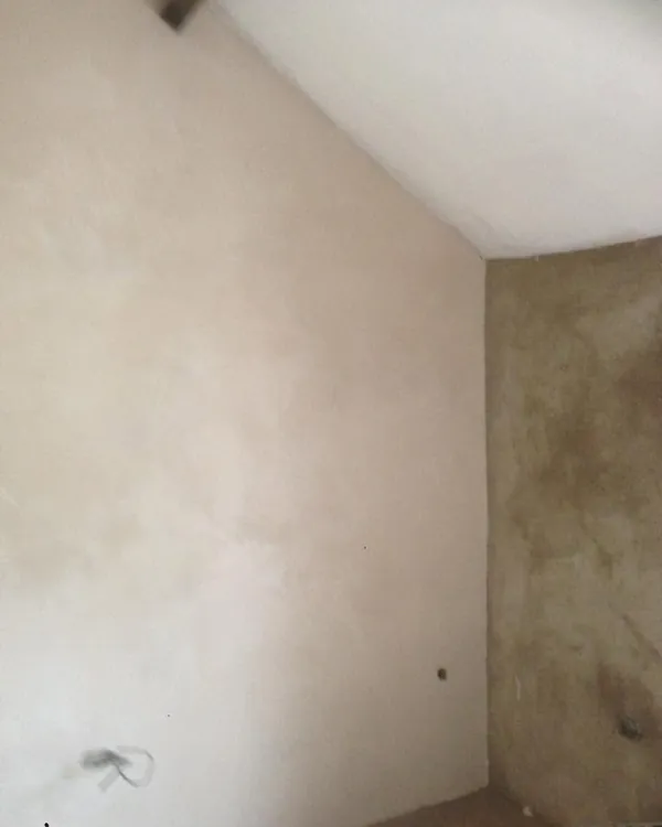 Freshly plastered wall meeting an unplastered wall in the same room